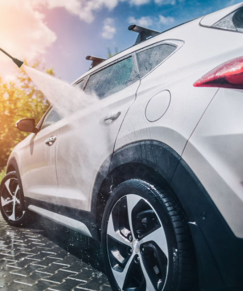 A white car is spraying water on the street